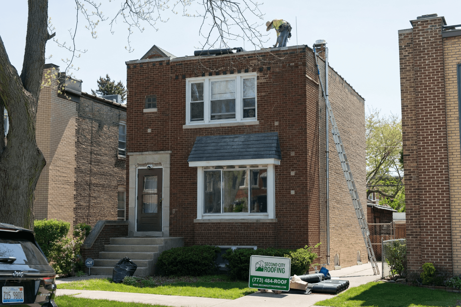 Single-family house with flat roof being repaired in Chicago